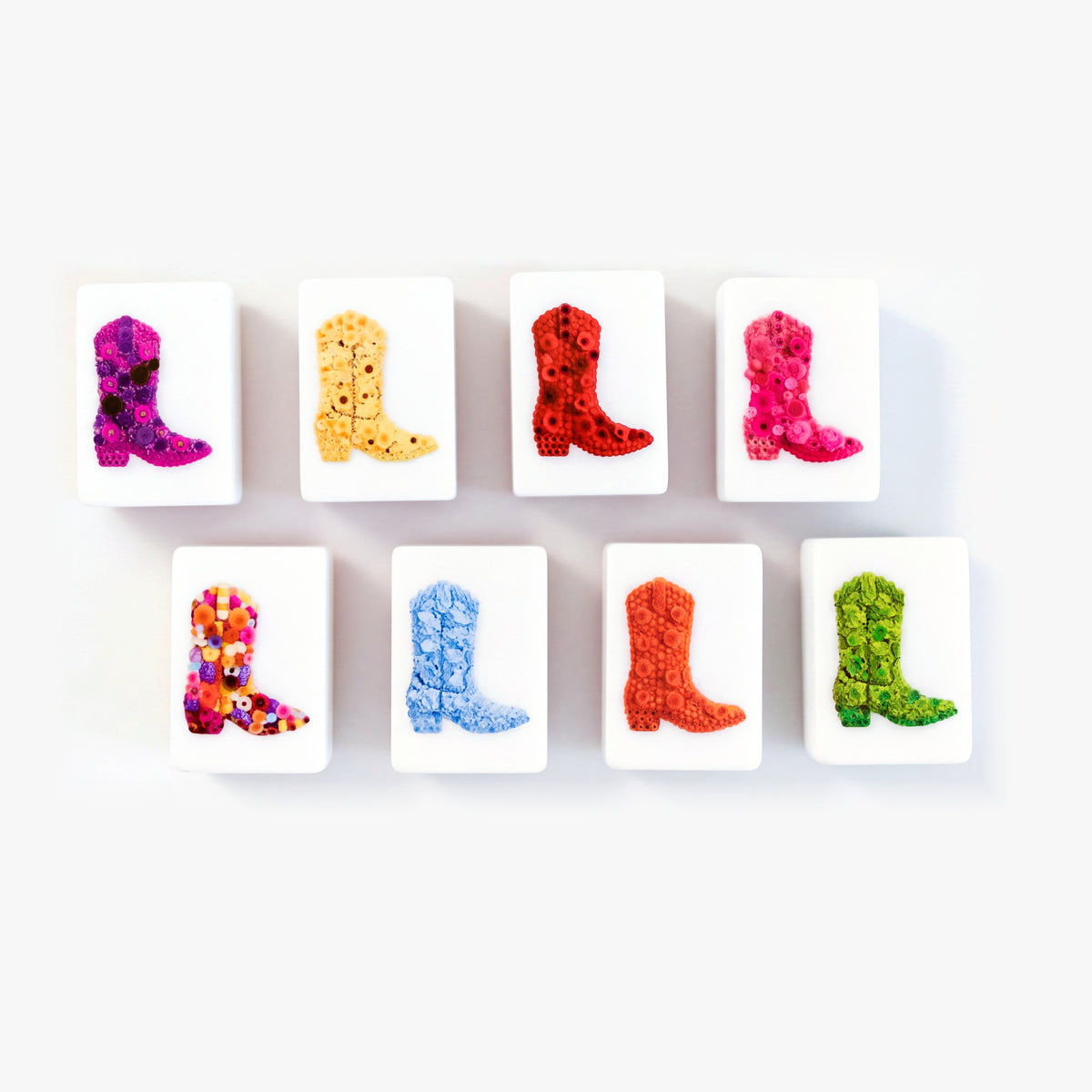 Eight flower tiles from The Dallas Collective, each showing a flower-covered cowboy boot in a different color