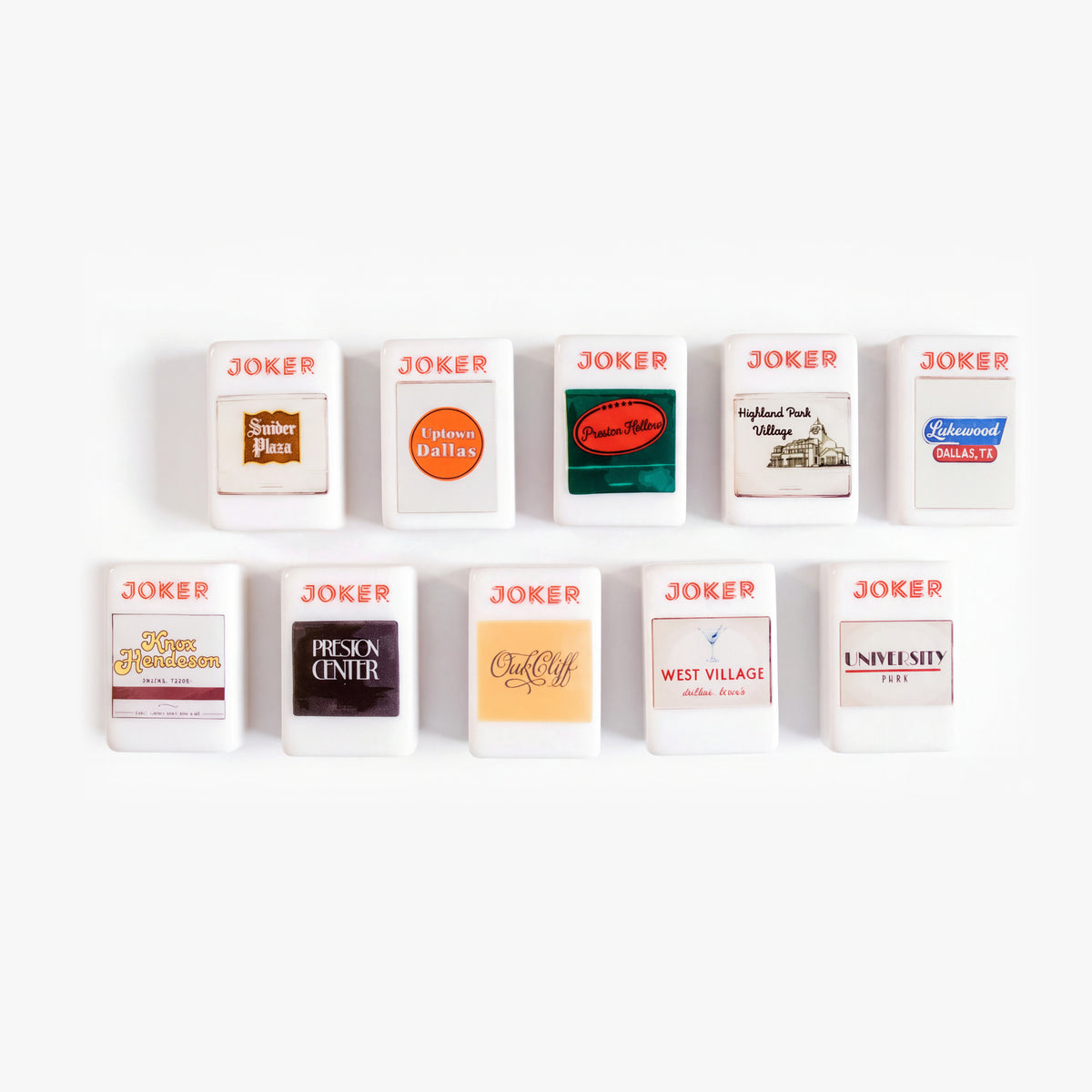 Ten Joker tiles from The Dallas Collective with matchbook-style labels for Dallas neighborhoods like Highland Park Village, Uptown and Oak Cliff